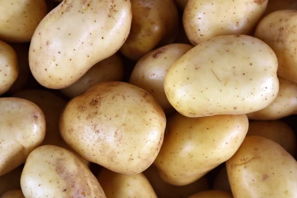 Patatas sobre el fondo de textura del mercado — Foto de Stock