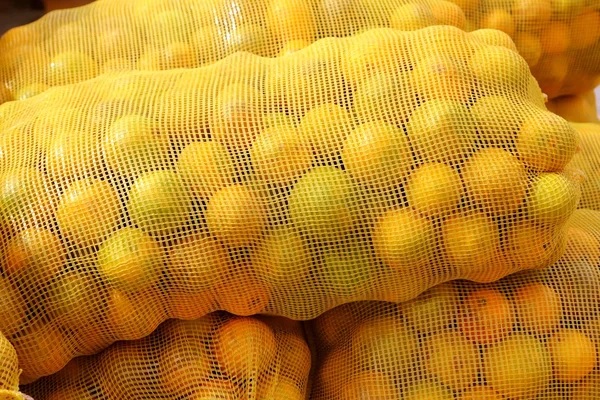 Oranje zak gestapelde citrusvruchten — Stockfoto