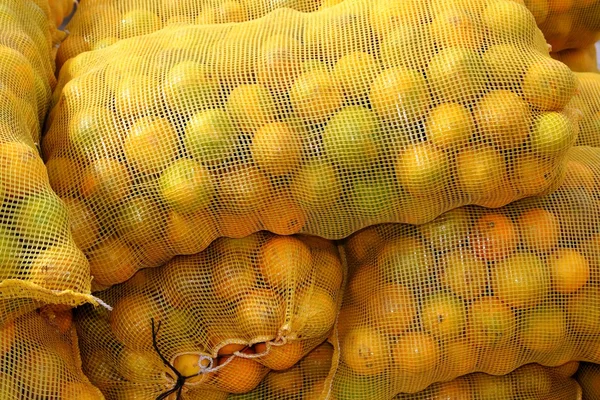 Oranje zak gestapelde citrusvruchten — Stockfoto