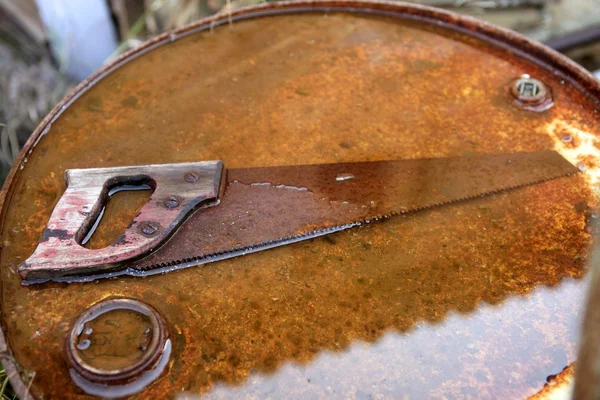 Arrugginito vecchio strumento sega su sfondo arrugginito — Foto Stock
