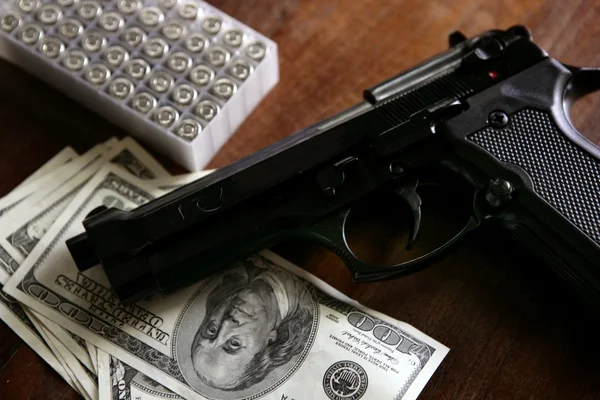 Dolarových bankovek a zbraň, černá pistole — Stock fotografie