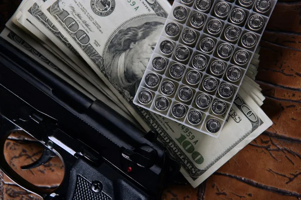 Dolarových bankovek a zbraň, černá pistole — Stock fotografie