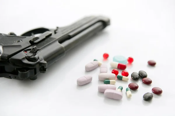 Pistola ou pílulas duas opções de suicídio — Fotografia de Stock