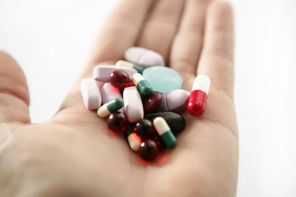 Таблетки над білим, здоров'я або самогубство — стокове фото