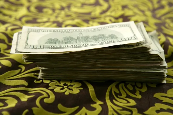 Many dollar notes over tablecloth — Stock Photo, Image