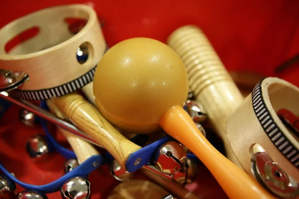 Mixed percussion toy instruments on red — Stock Photo, Image