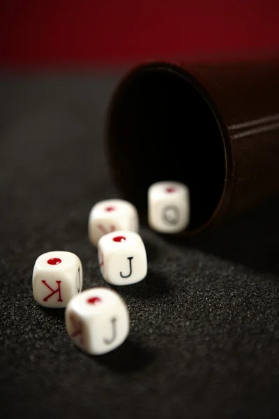 黒いテーブル上の火かき棒ゲームのサイコロ — ストック写真