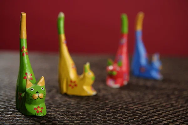 Four handcraft cats in colors still over tablecloth — Stock Photo, Image
