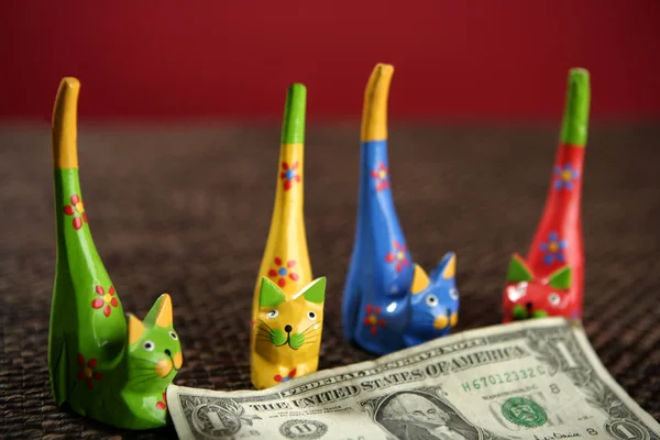 Four handcraft cats arroun one dollar note — Stock Photo, Image