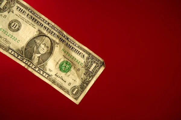 Uma nota de dólar sobre fundo vermelho — Fotografia de Stock