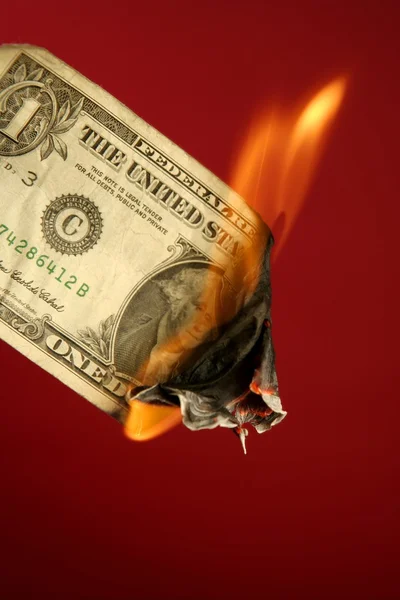 Dollar note burning in fire over red — Stock Photo, Image