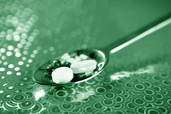 Colher de prata cheia de comprimidos de medicina — Fotografia de Stock