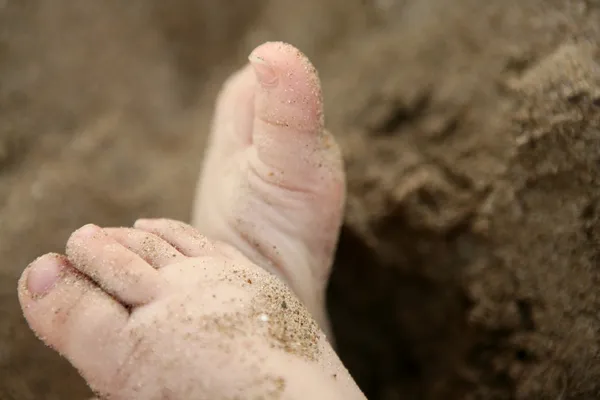 Bébé pieds sur la plage de sable — Photo