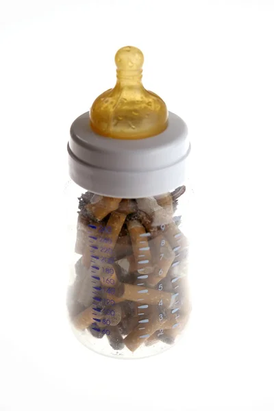 Детская бутылочка с сигаретами — стоковое фото