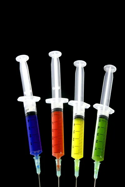 Colorful syringes set, health, medicine, over black — Stock Photo, Image