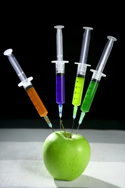 Манипуляция яблоками со шприцами — стоковое фото