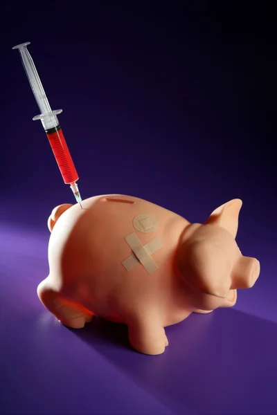 Piggy bank com seringa, metáfora financeira — Fotografia de Stock