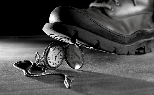 Old boot treading a vintage pocket watch