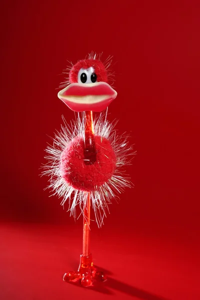 Funny red ostrich toy with candy hot lips — Stock Photo, Image