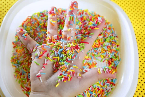 Crianças mão cheia de pequenos doces coloridos — Fotografia de Stock