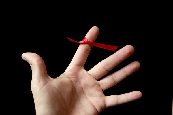 赤テープ リボンのヒト手指の周りにループ テープ — ストック写真