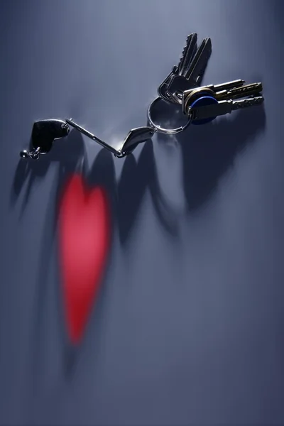 Ключи с красным светом сердца на тени — стоковое фото