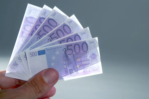 Dedos humanos segurando pouca moeda notas de euro — Fotografia de Stock