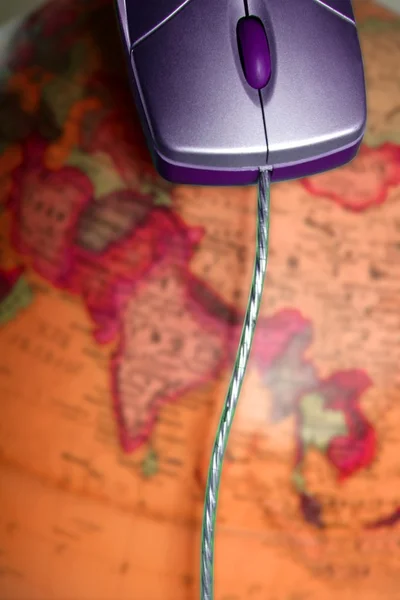Υπολογιστή ενσύρματο ποντίκι πάνω στον παγκόσμιο χάρτη του παγκόσμιου — Φωτογραφία Αρχείου