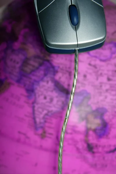 Υπολογιστή ενσύρματο ποντίκι πάνω στον παγκόσμιο χάρτη του παγκόσμιου — Φωτογραφία Αρχείου