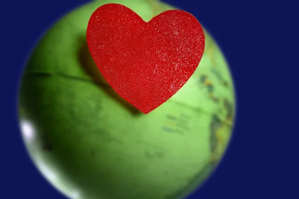 Candy Valentine coração sobre o mundo verde mapa global da terra — Fotografia de Stock