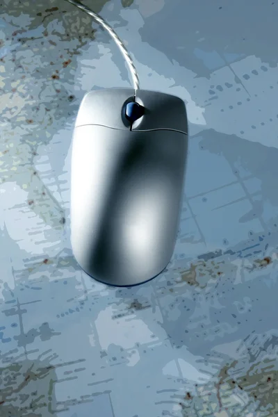 Computer silver wired mouse over blue map — Stock Photo, Image