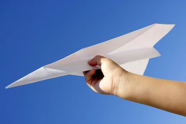 푸른 하늘 위에 어린이 손으로 종이 비행기 — 스톡 사진