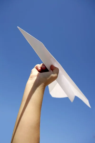 Avión de papel en niños entrega cielo azul —  Fotos de Stock