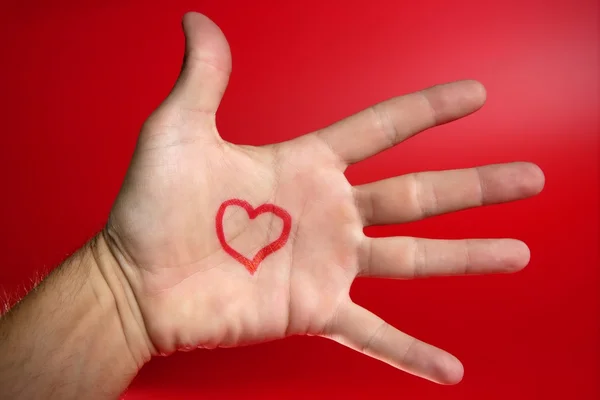 Forma de coração vermelho desenhado em uma mão humana masculina — Fotografia de Stock