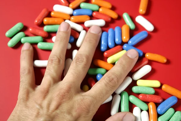 Mão humana segurando doces coloridos — Fotografia de Stock