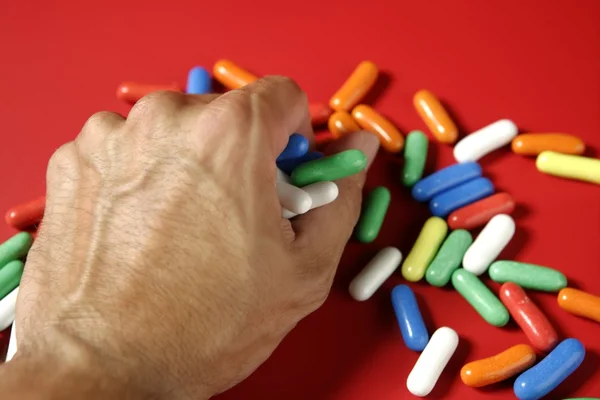 Человеческая рука держит красочные конфеты — стоковое фото