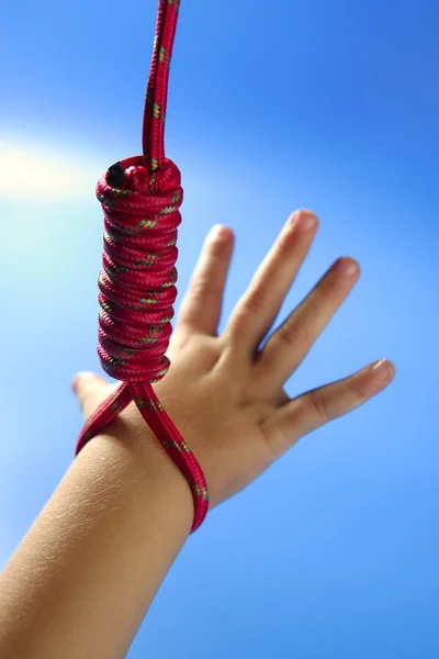 Children hand hanged on red thread — Stock Photo, Image