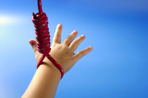 Рука детей висит на красной нитке — стоковое фото