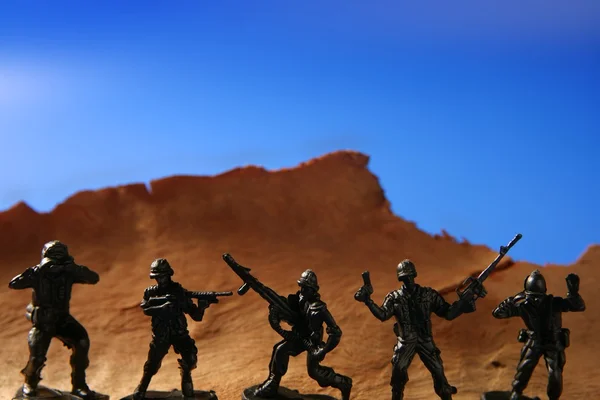 木製山の向こうのプラスチックおもちゃの兵隊 — ストック写真