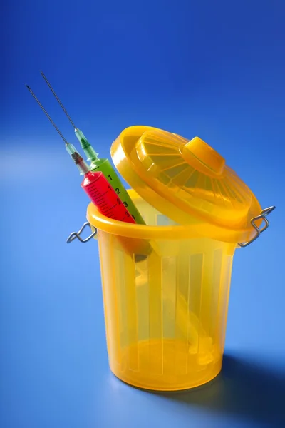 Two red and green syringe on the trash — Stock Photo, Image