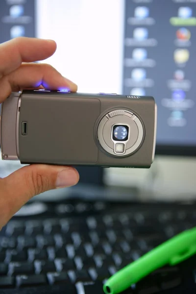 Fotocamera cellulare, tastiera e schermo del computer — Foto Stock