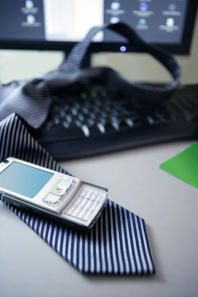 Liet zijn stropdas en telefoon over computertoetsenbord — Stockfoto