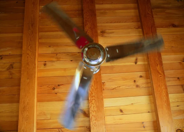 Silver ceiling fan on a golden wooden beams — Stock Photo, Image