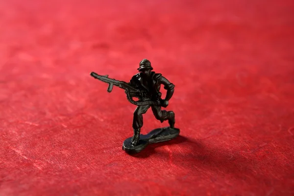 Plastic toy soldier over red — Stock Photo, Image