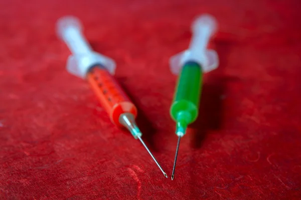 Dos jeringas rojas y verdes, salud, adicción, investigación médica — Foto de Stock