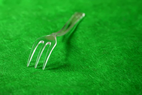 Fourchette en plastique transparent sur une texture vive — Photo