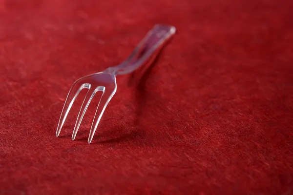 Transparent plast gaffel på ett texturerat levande — Stockfoto