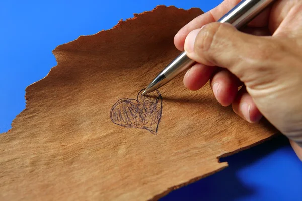 Desenho com uma caneta um coração em madeira — Fotografia de Stock