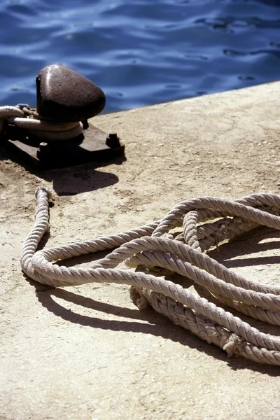 Болард, веревки и узлы в средиземноморской гавани — стоковое фото