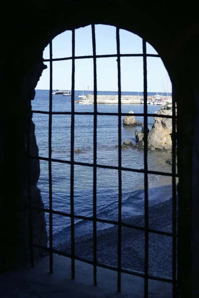 Blauwe zee achter de jail, boog venster — Stockfoto